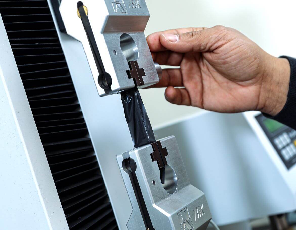 Man working with a plastic testing machine.